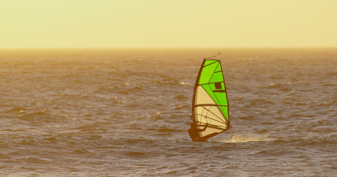 Windsurfer Gliding Across Ocean with Golden Sunset - Free Images, Stock Photos and Pictures on Pikwizard.com