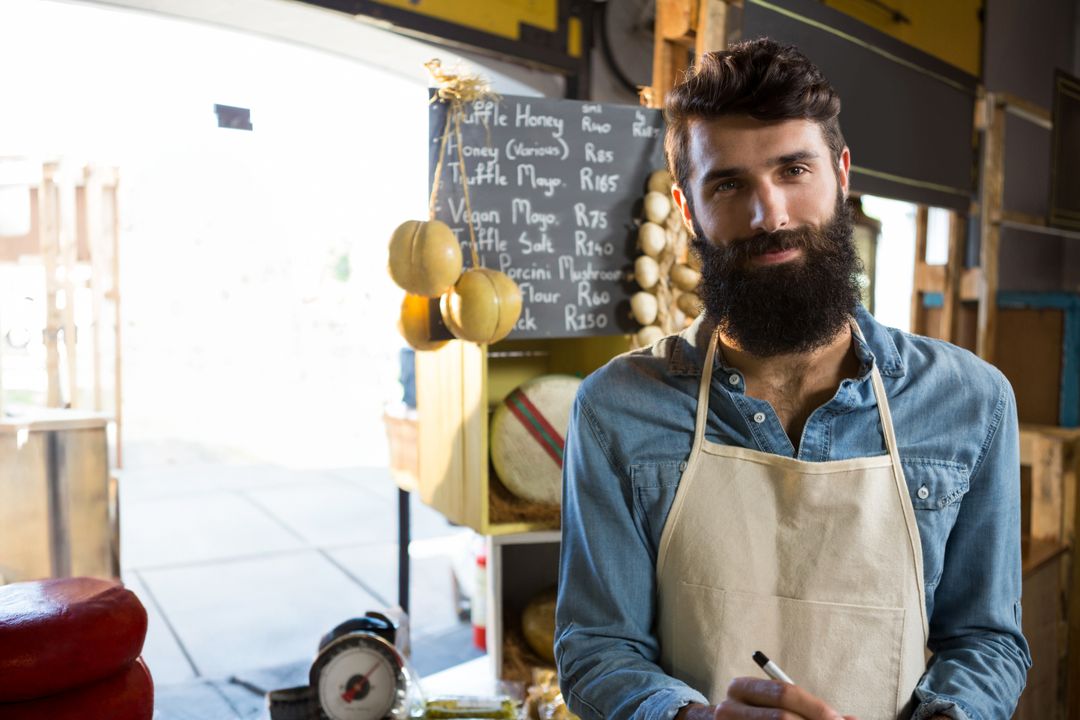 Artisan Bearded Vendor Proudly Displaying Fresh Cheese Selection
