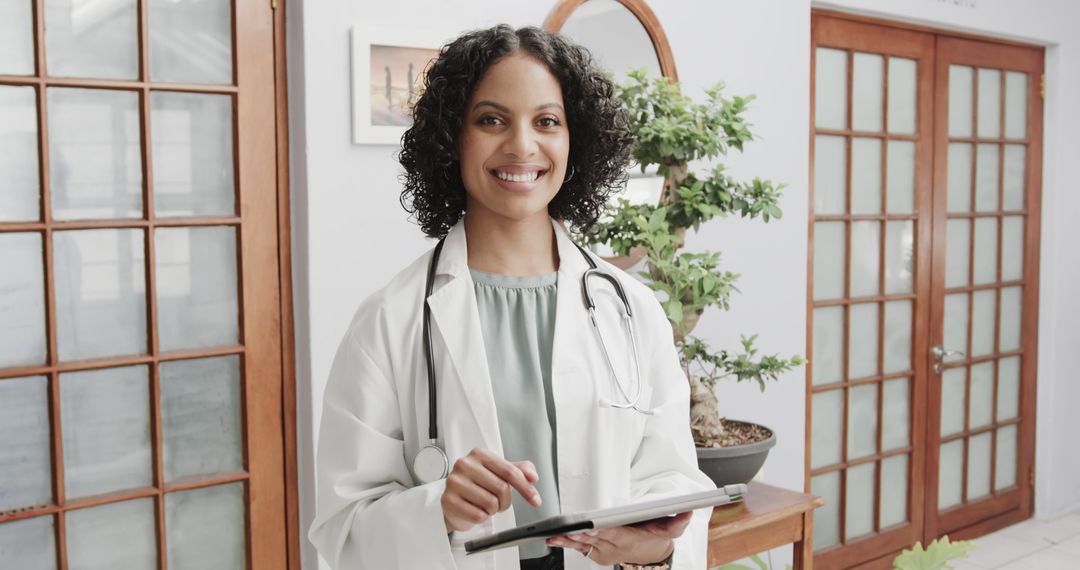 Smiling Female Doctor Holding Clipboard in Modern Medical Office - Free Images, Stock Photos and Pictures on Pikwizard.com