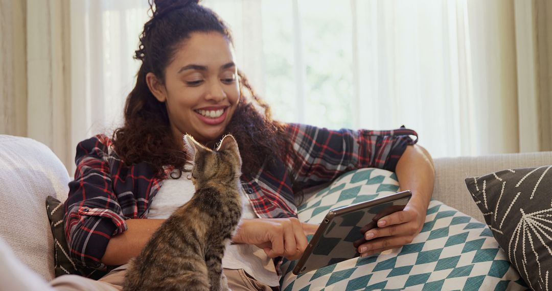 Young Woman Relaxing at Home with Cat Using Tablet