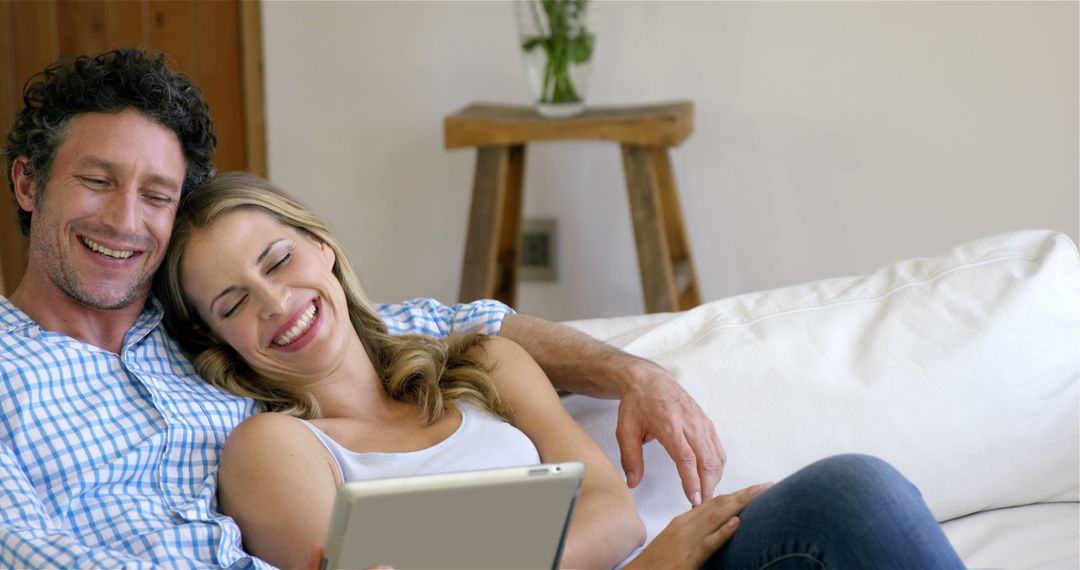 Couple using a tablet in the living room - Free Images, Stock Photos and Pictures on Pikwizard.com