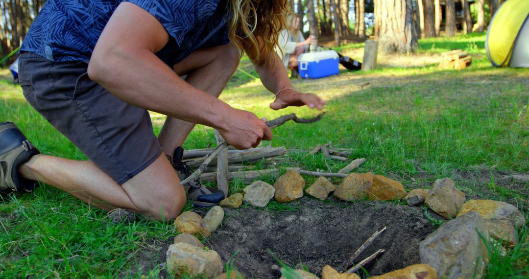 Man Preparing Campfire in Forest Clearing - Free Images, Stock Photos and Pictures on Pikwizard.com