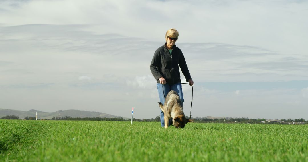 Woman Walking Dog on Leash in Open Field - Free Images, Stock Photos and Pictures on Pikwizard.com