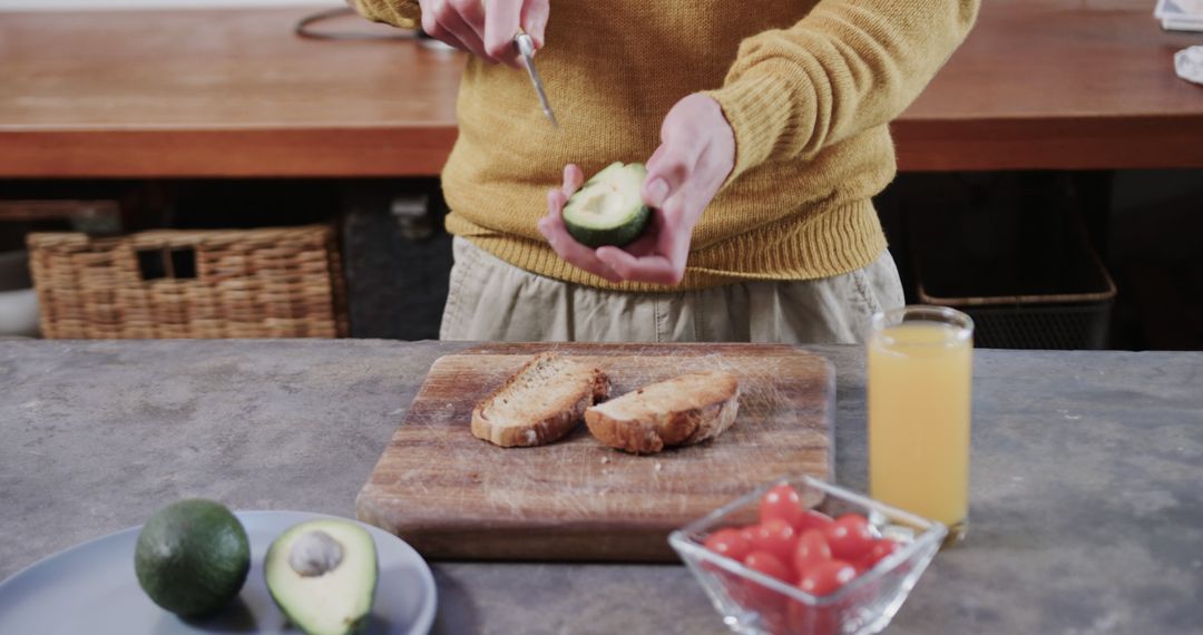 Person Preparing Avocado On Toast With Fresh Ingredients In Kitchen - Free Images, Stock Photos and Pictures on Pikwizard.com