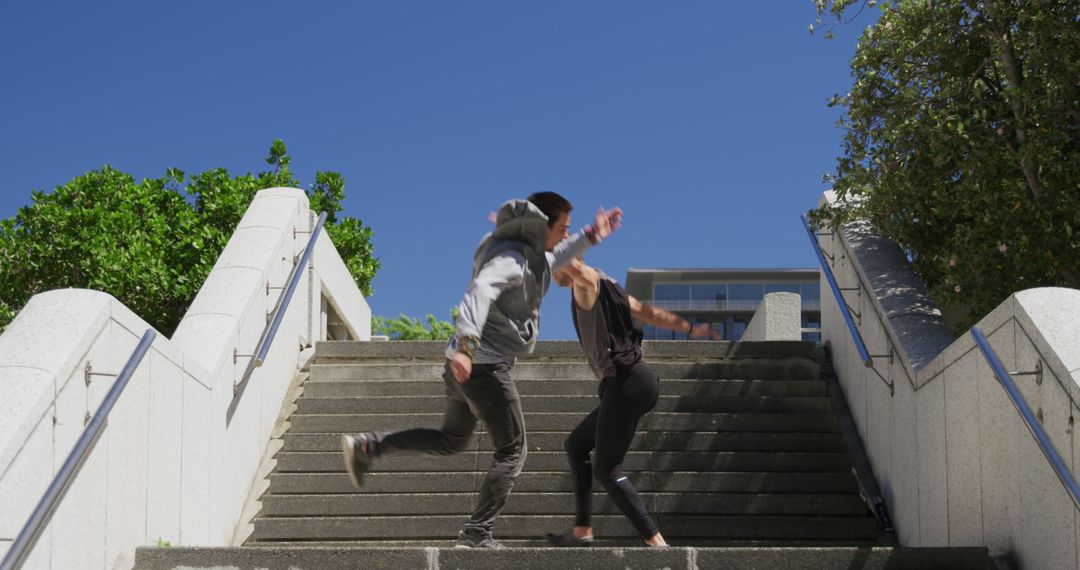 Free Runners Freestyle Jump on Urban Steps on Sunny Day