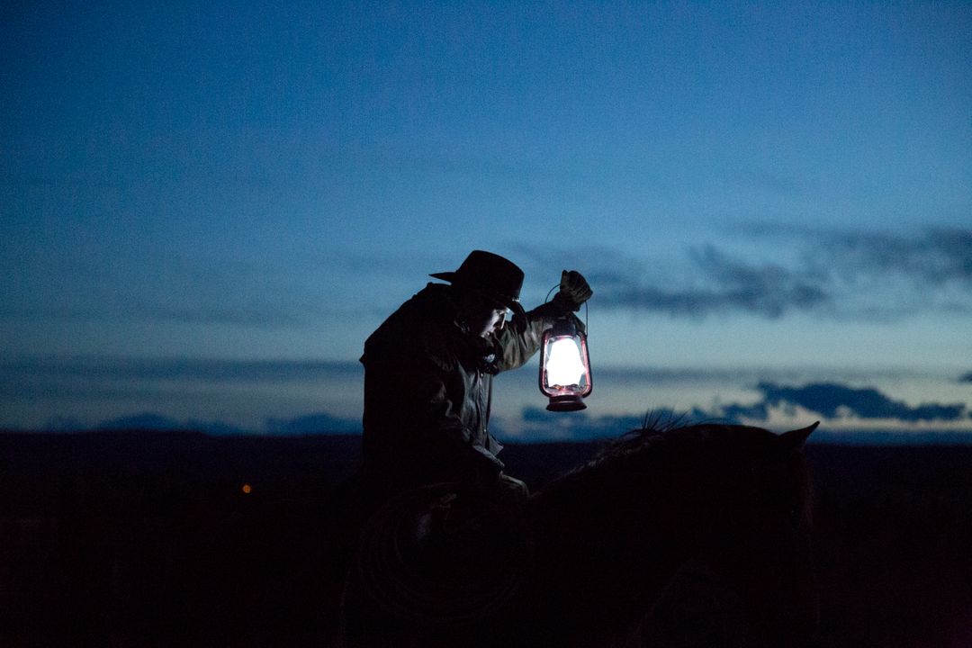 Silhouetted Cowboy Holding Lantern on Horse at Dusk - Free Images, Stock Photos and Pictures on Pikwizard.com