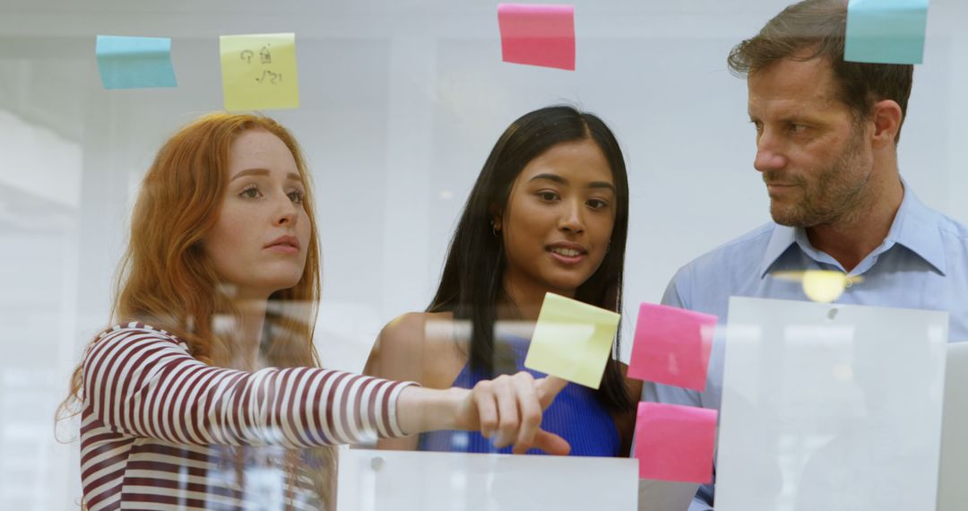 Diverse Team Collaborating with Post-It Notes on Glass Wall - Free Images, Stock Photos and Pictures on Pikwizard.com