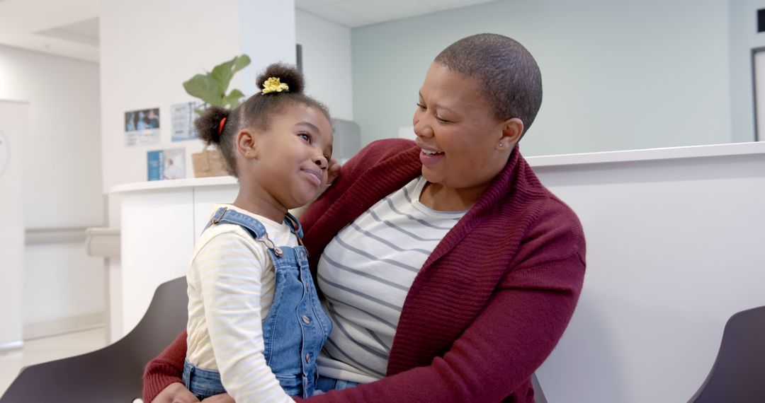 Mother and Daughter Smiling Together in Waiting Room - Free Images, Stock Photos and Pictures on Pikwizard.com