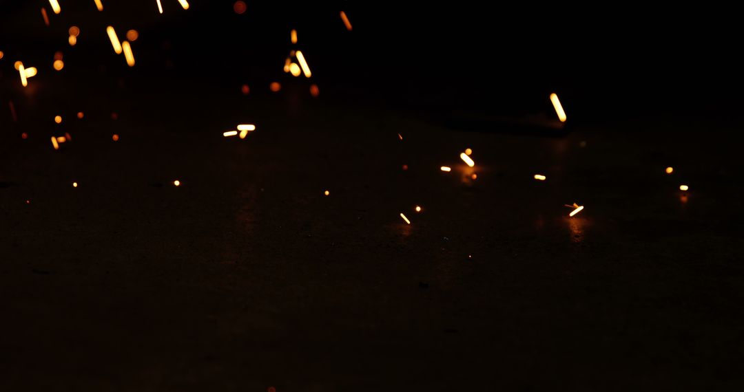 Glowing Sparks Flying in Dark Industrial Workshop - Free Images, Stock Photos and Pictures on Pikwizard.com