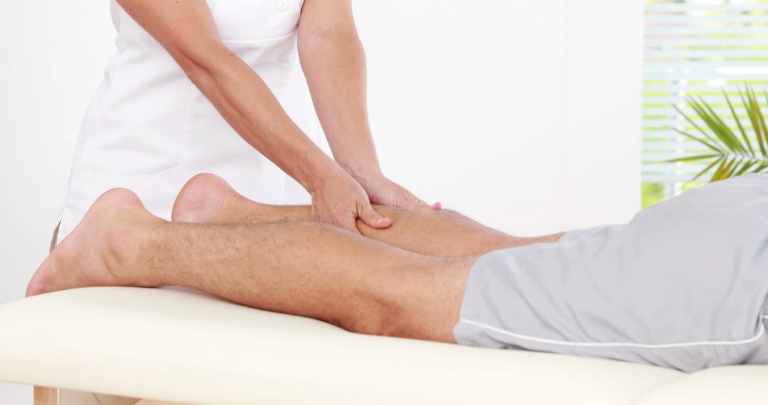 Physical Therapist Massaging Patient's Leg on Treatment Table - Free Images, Stock Photos and Pictures on Pikwizard.com