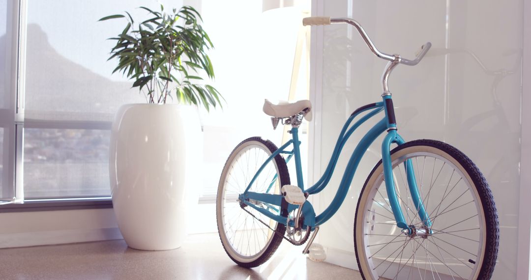 A vintage blue bicycle is parked indoors near a window with a view of a mountain, with copy space - Free Images, Stock Photos and Pictures on Pikwizard.com