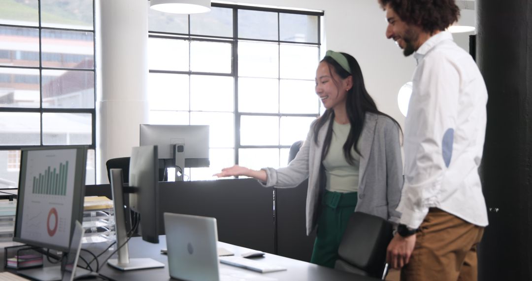 Business Professionals Discussing Charts in Modern Office Environment