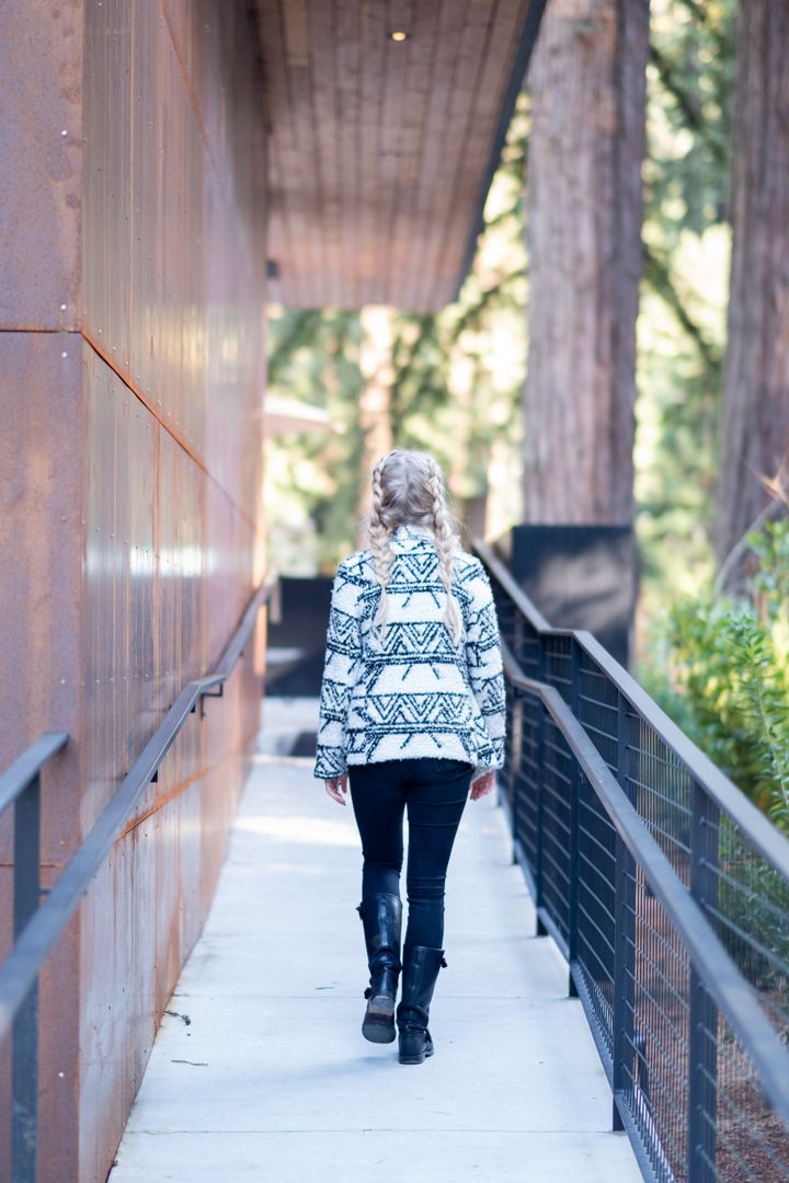 Woman Walking in Forest Surrounded by Cedar Trees
