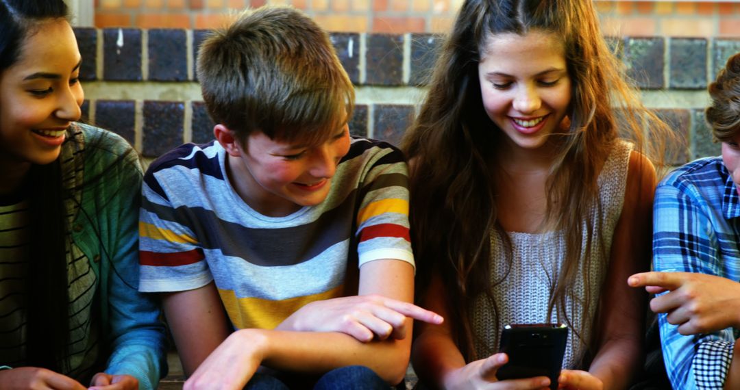 Smiling Teens Using Smartphone Outdoors and Enjoying Social Media - Free Images, Stock Photos and Pictures on Pikwizard.com