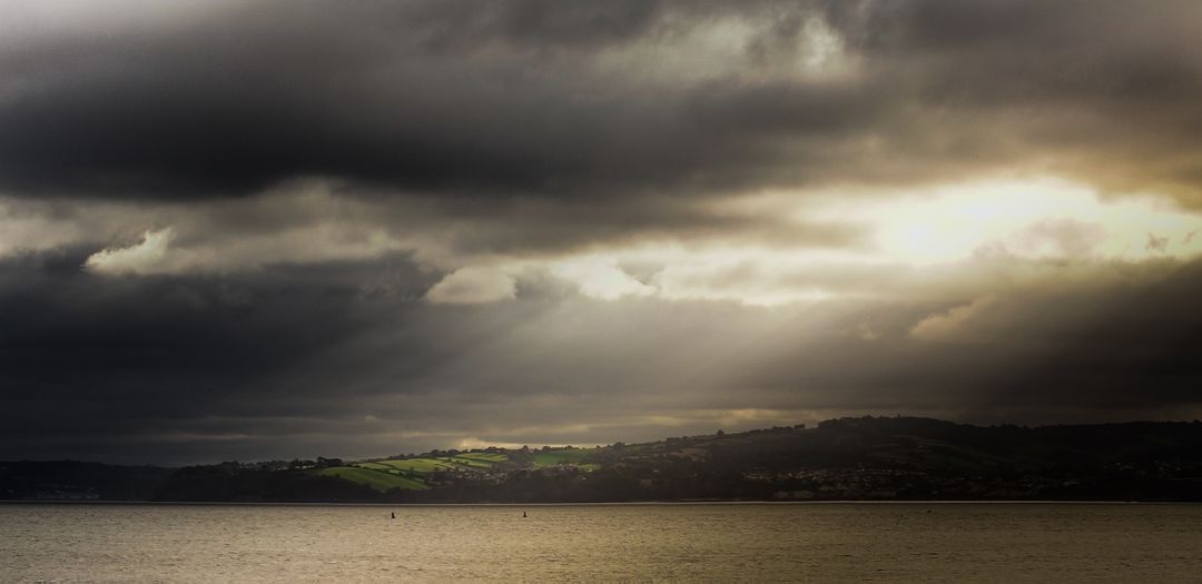 Dramatic Sky Over Coastal Landscape with Sunbeams - Free Images, Stock Photos and Pictures on Pikwizard.com