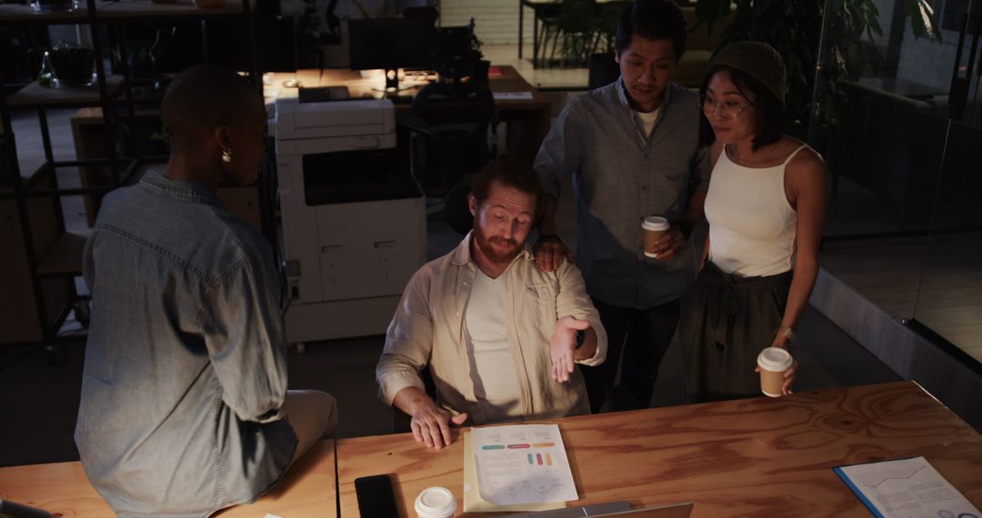 Diverse Team Collaborating on Project Late at Night