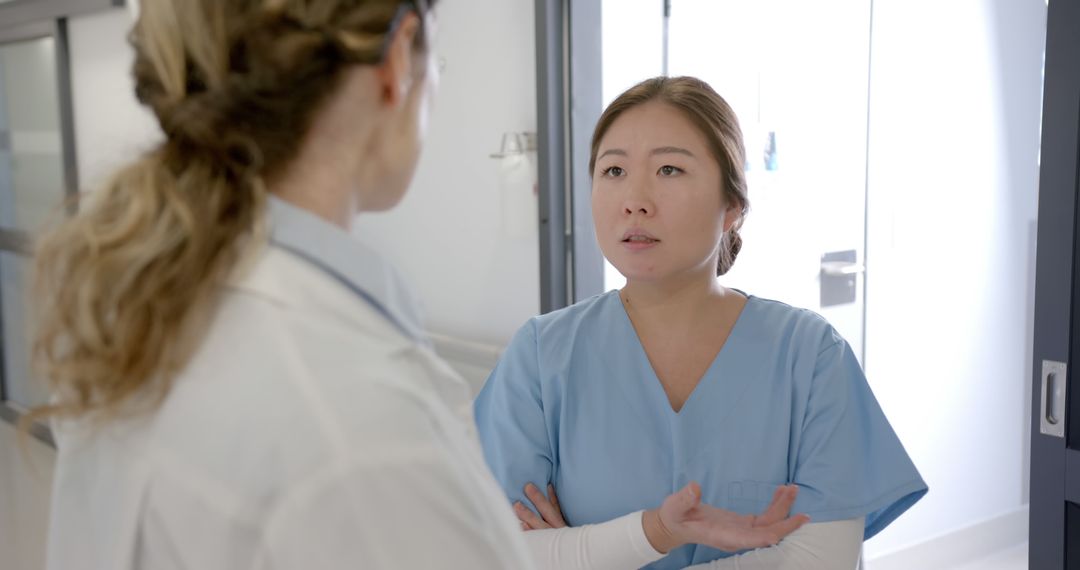 Two Female Healthcare Workers Having a Serious Discussion in Hospital - Free Images, Stock Photos and Pictures on Pikwizard.com