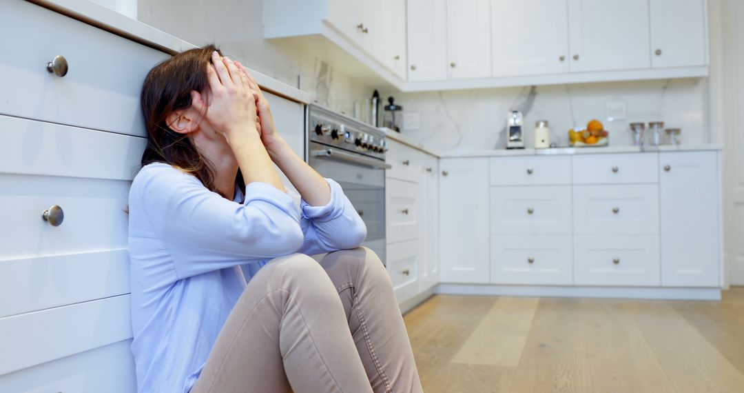 Woman Sitting on Kitchen Floor Appears Stressed: Mental Health and Lifestyle Concepts - Free Images, Stock Photos and Pictures on Pikwizard.com