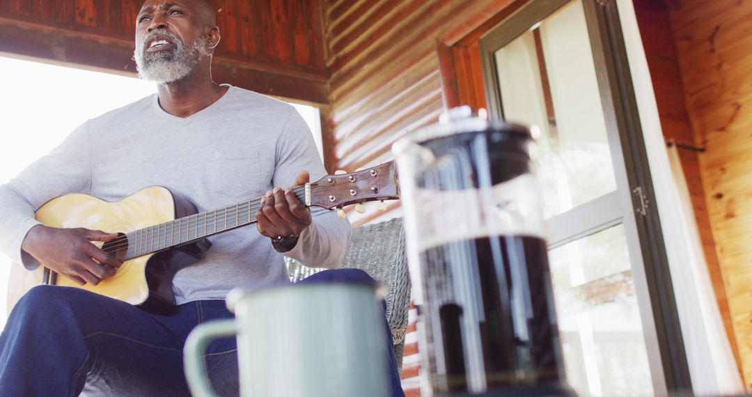 African American Man Playing Guitar on Porch with Coffee - Free Images, Stock Photos and Pictures on Pikwizard.com
