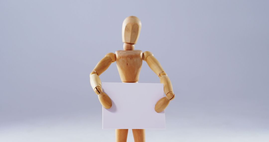 Wooden Mannequin Holding Blank Card On Light Background - Free Images, Stock Photos and Pictures on Pikwizard.com