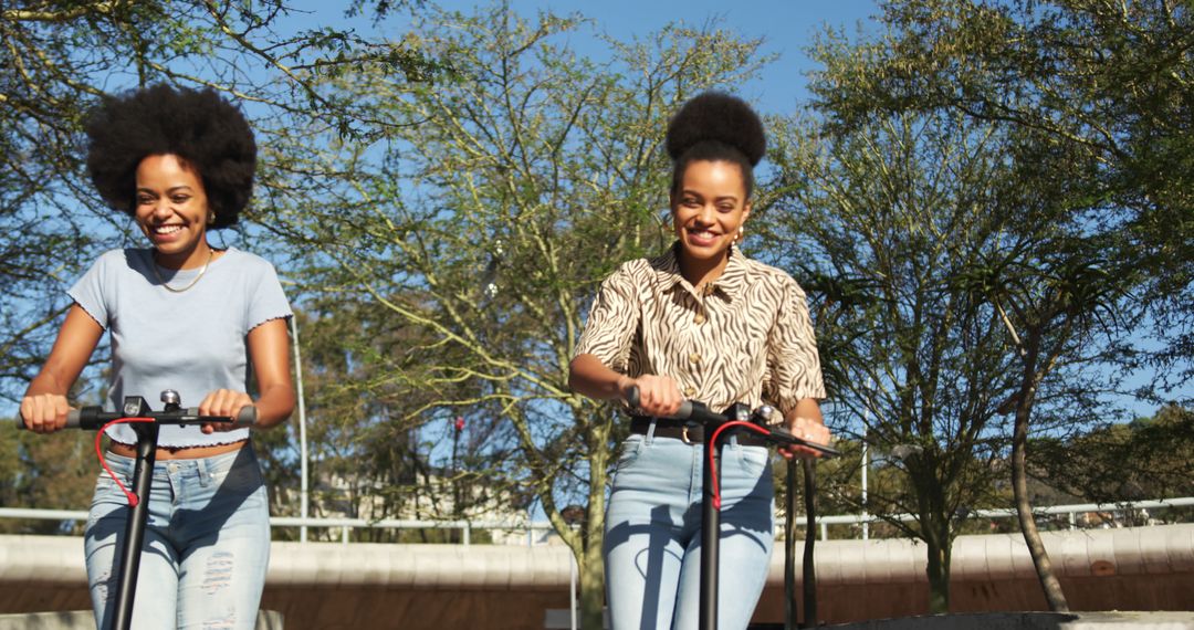 Young Women Enjoying Electric Scooter Ride in Park - Free Images, Stock Photos and Pictures on Pikwizard.com