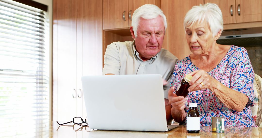 Senior Couple Researching Prescription Medication on Laptop in Kitchen - Free Images, Stock Photos and Pictures on Pikwizard.com