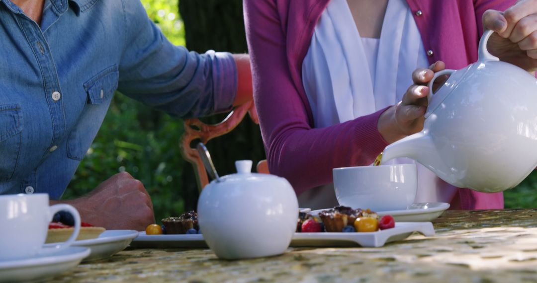 People Enjoying Afternoon Tea in Outdoor Garden Setting - Free Images, Stock Photos and Pictures on Pikwizard.com