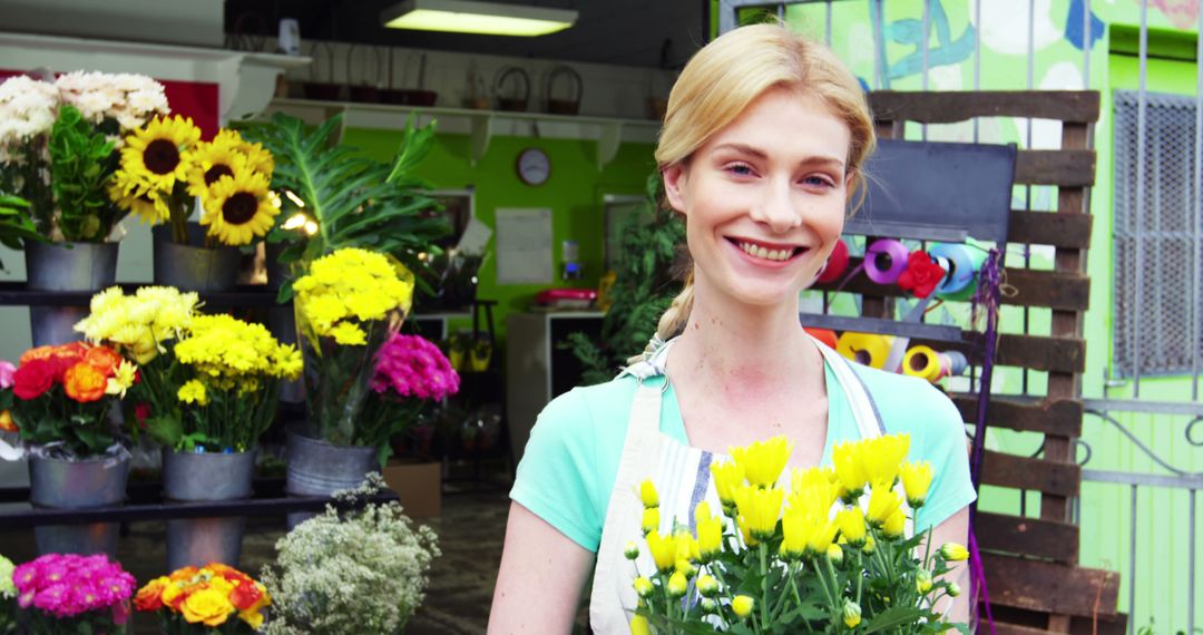 Smiling Florist Holding Yellow Flowers in Bright Shop - Free Images, Stock Photos and Pictures on Pikwizard.com