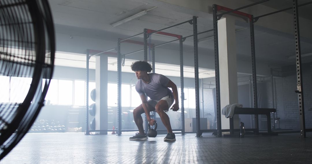 Man Performing Kettlebell Exercise in Spacious Gym
