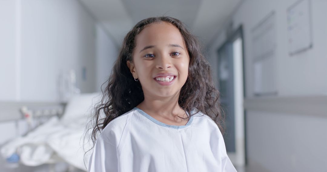 Smiling Girl in Hospital Corridor Wearing Patient Gown - Free Images, Stock Photos and Pictures on Pikwizard.com