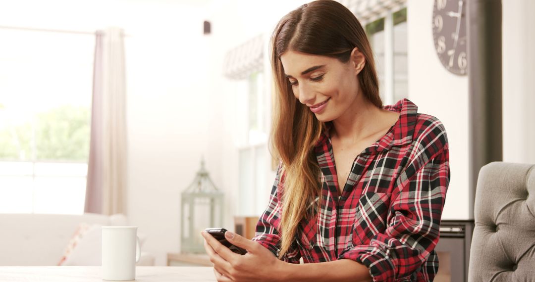 Smiling Woman Using Smartphone While Relaxing with Coffee at Home