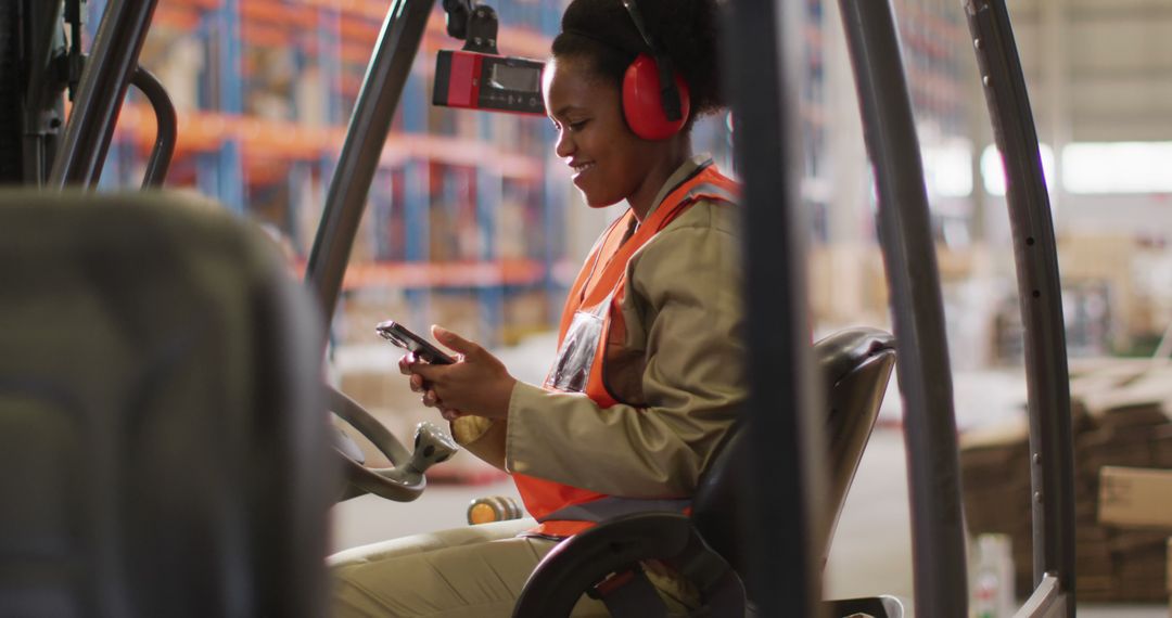 Female Warehouse Worker Operating Forklift and Using Phone - Free Images, Stock Photos and Pictures on Pikwizard.com