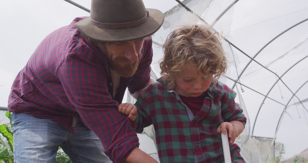 Father Teaching Young Son About Gardening in Greenhouse - Free Images, Stock Photos and Pictures on Pikwizard.com