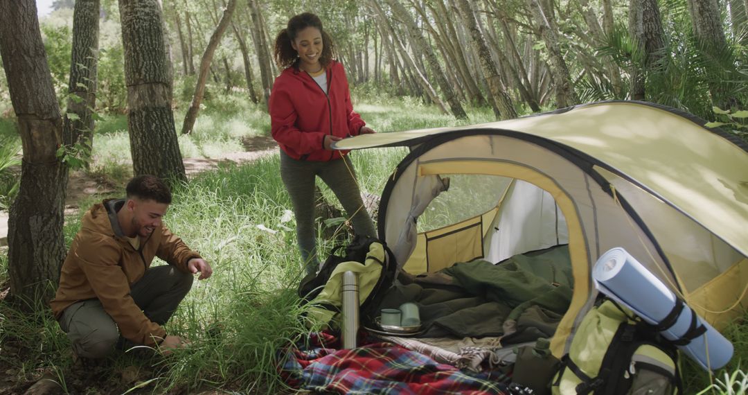 Happy Couple Setting Up Camp in Forest Clearing - Free Images, Stock Photos and Pictures on Pikwizard.com