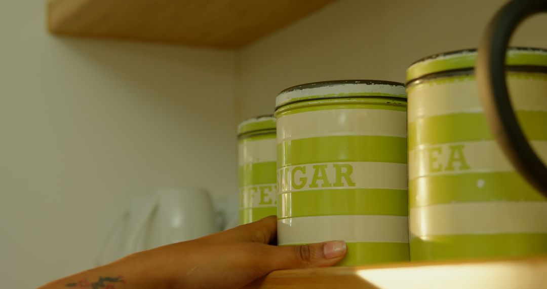 Hand Reaching for Tea Canister on Kitchen Shelf - Free Images, Stock Photos and Pictures on Pikwizard.com