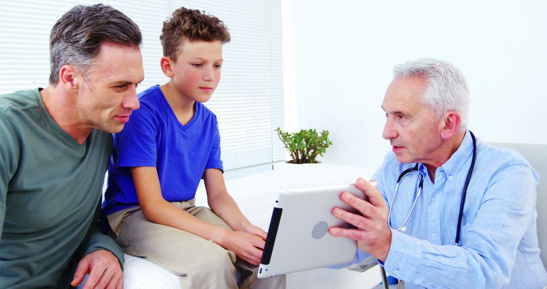 Doctor Consulting Father and Son Using Digital Tablet in Bright Clinic - Free Images, Stock Photos and Pictures on Pikwizard.com