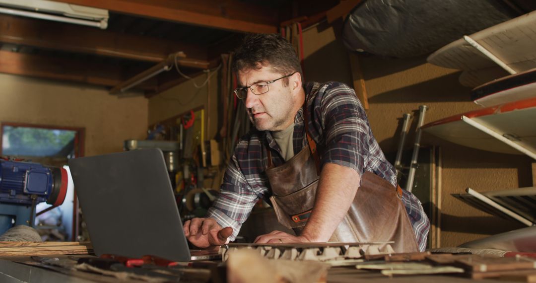 Craftsman Knife Maker in Workshop Uses Laptop for Design