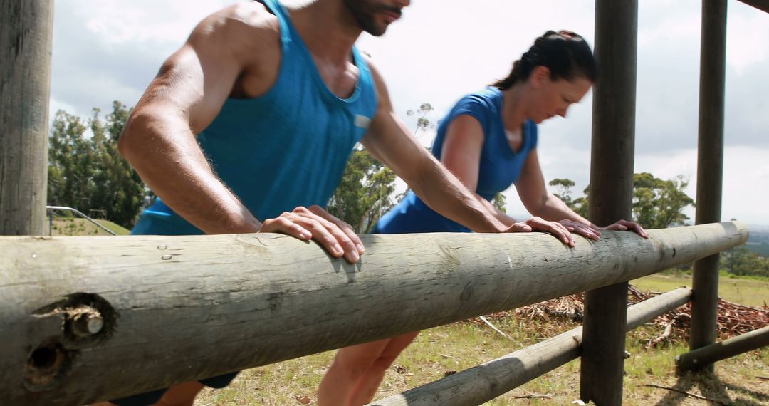 Fit Individuals Doing Push-ups Outdoors on Obstacle Course