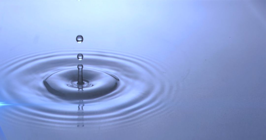 Water Droplets Creating Ripples with Soft Blue Glow
