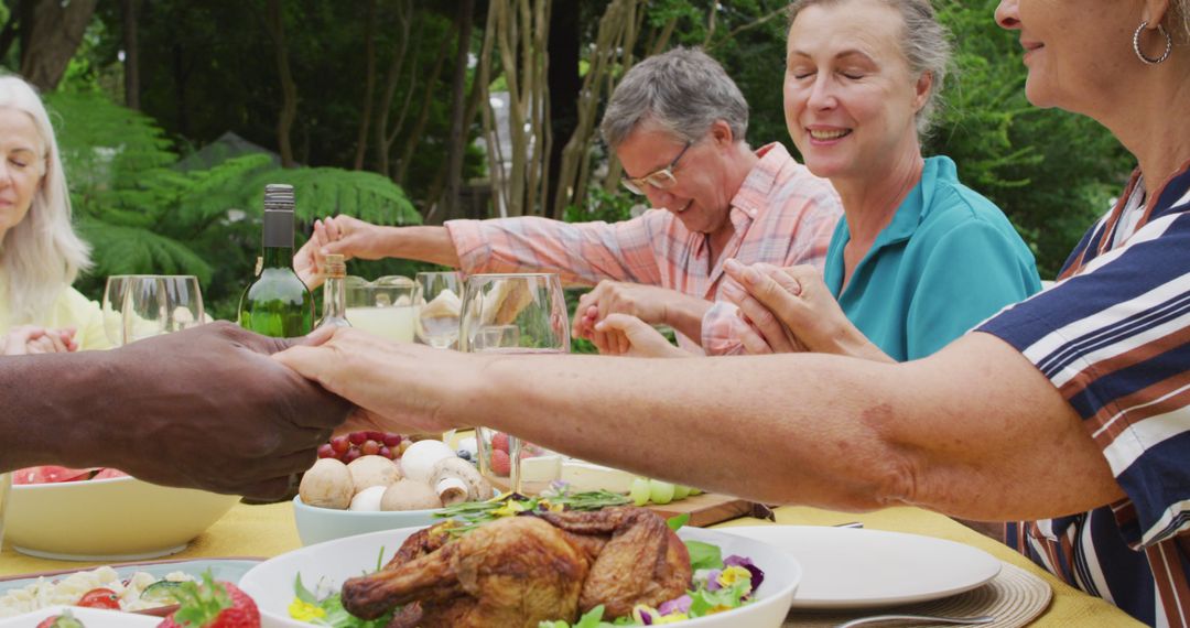 Diverse Senior Friends Praying Together at Outdoor Meal - Free Images, Stock Photos and Pictures on Pikwizard.com