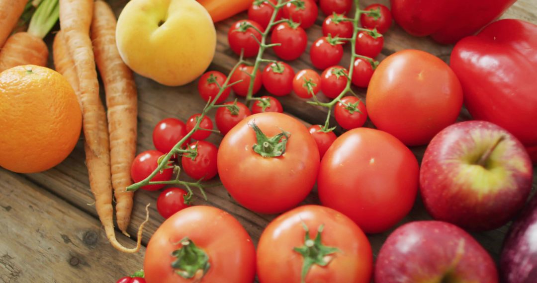 Displaying Fresh Red Tomatoes, Cherry Vine, Apples and Carrots on Rustic Wood