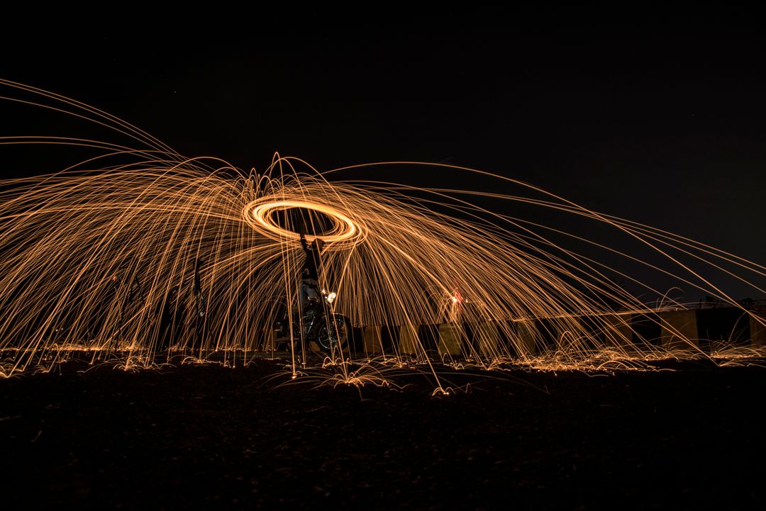 Person Spinning Ignited Steel Wool in Dark Night Sky - Free Images, Stock Photos and Pictures on Pikwizard.com