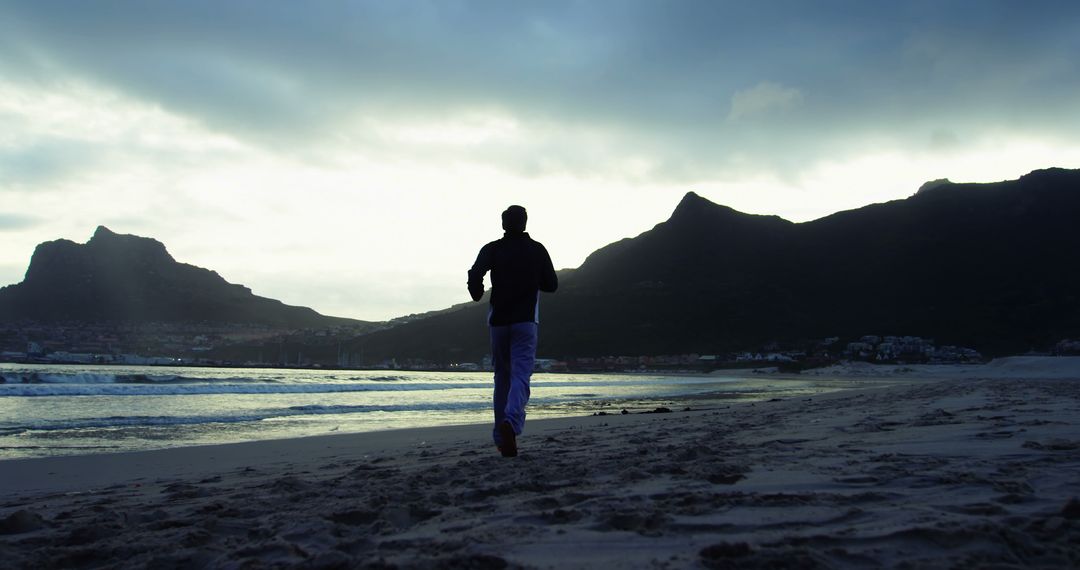 Silhouette of Person Jogging on Beach during Early Morning - Free Images, Stock Photos and Pictures on Pikwizard.com