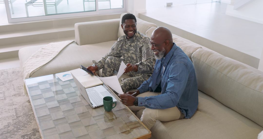 Father and Son Discussing Documents on Sofa