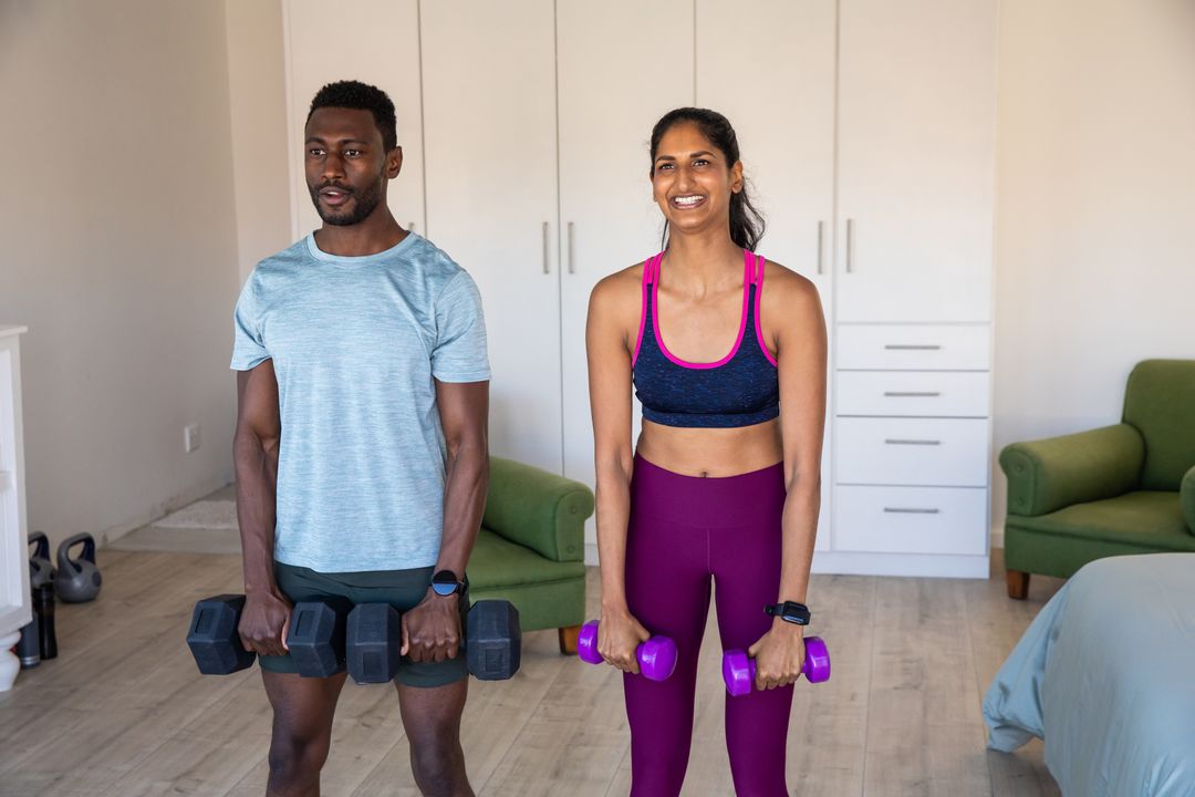 Diverse Partners Lifting Dumbbells in Cozy Home Environment