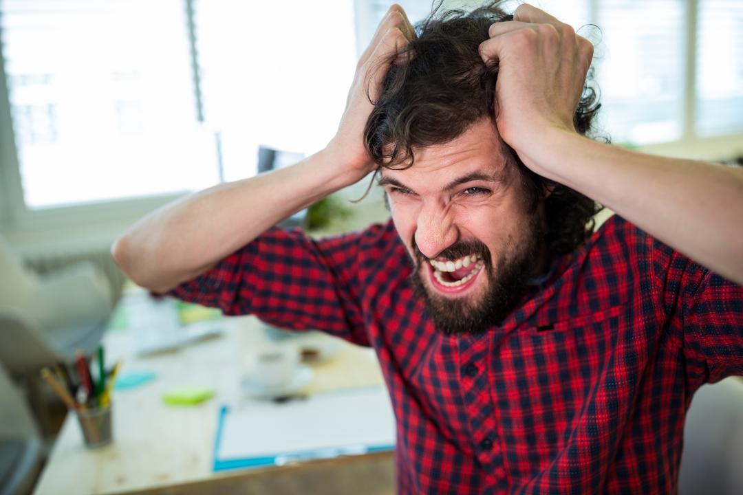 Frustrated Male Graphic Designer Pulling Hair in Office - Free Images, Stock Photos and Pictures on Pikwizard.com