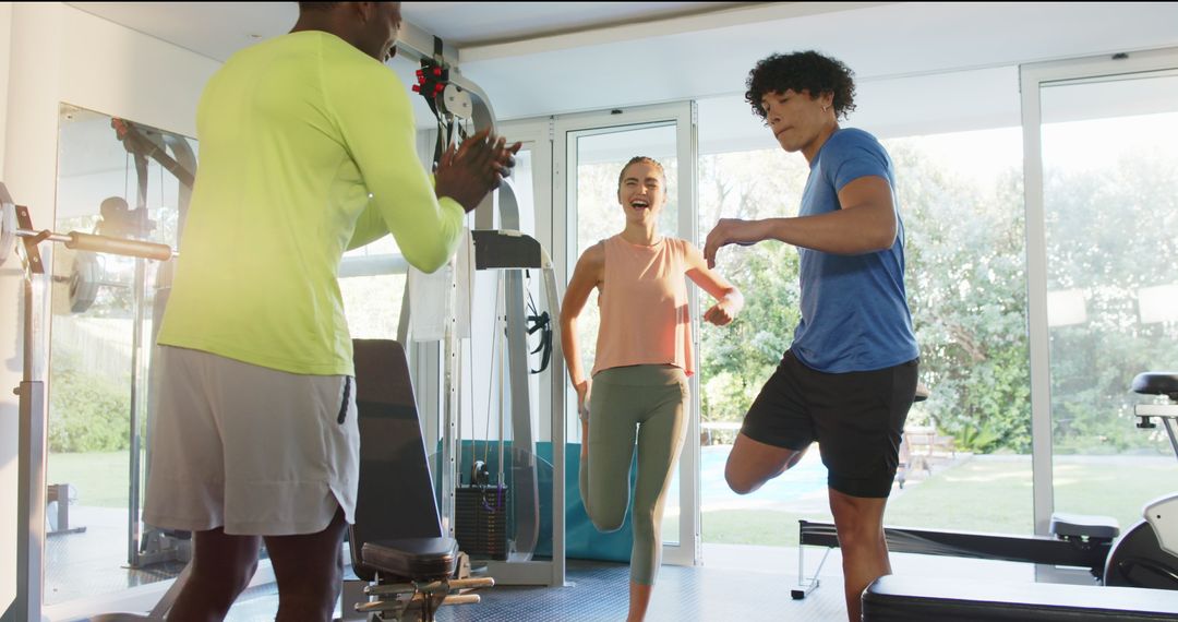 Enthusiastic Couple Exercising with Trainer in Modern Home Gym Setup