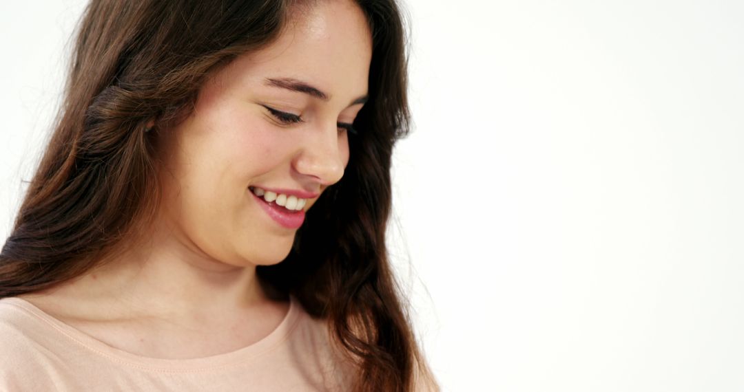 Smiling Woman with Long Dark Hair Looking Down - Free Images, Stock Photos and Pictures on Pikwizard.com