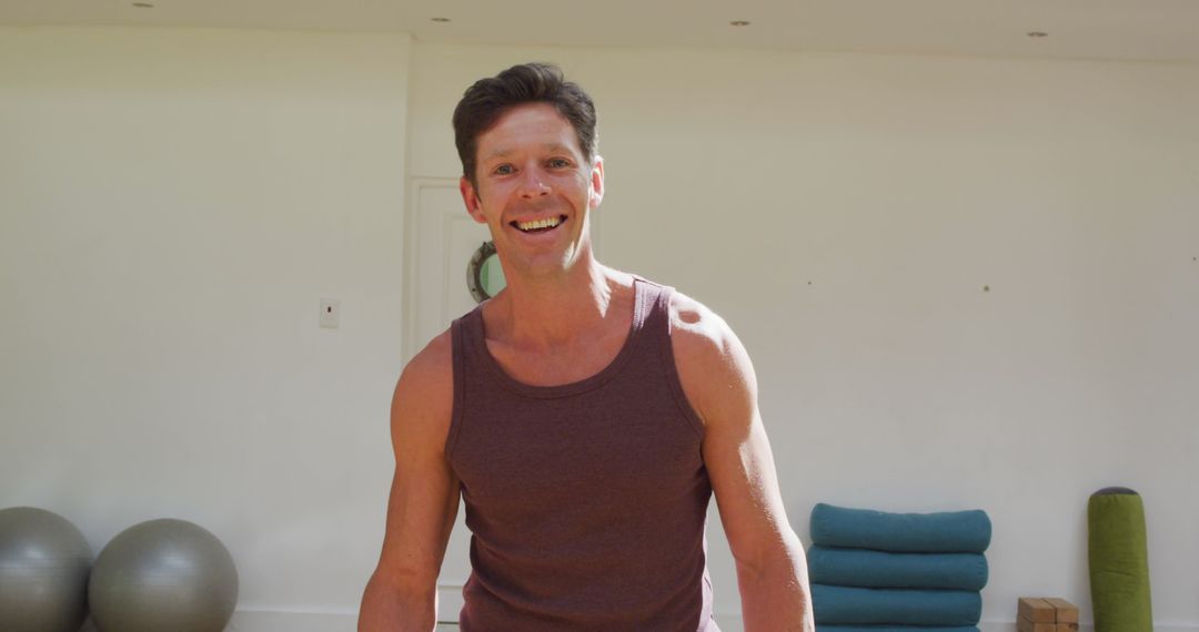 Smiling Yoga Instructor in Sunny Fitness Studio Environment
