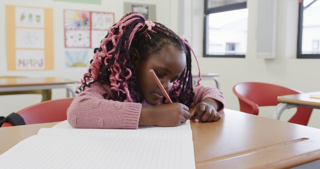 Focused Young Student Writing in Classroom Enhances Learning Skills